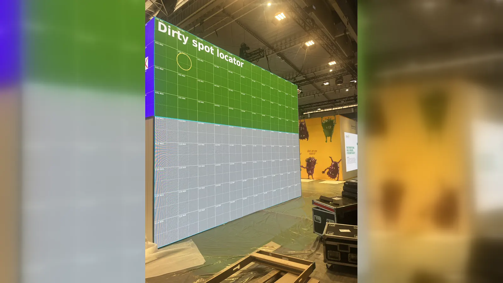 A yellow Dirty Spot ring identifying an exact area on a coordinate-labelled LED wall